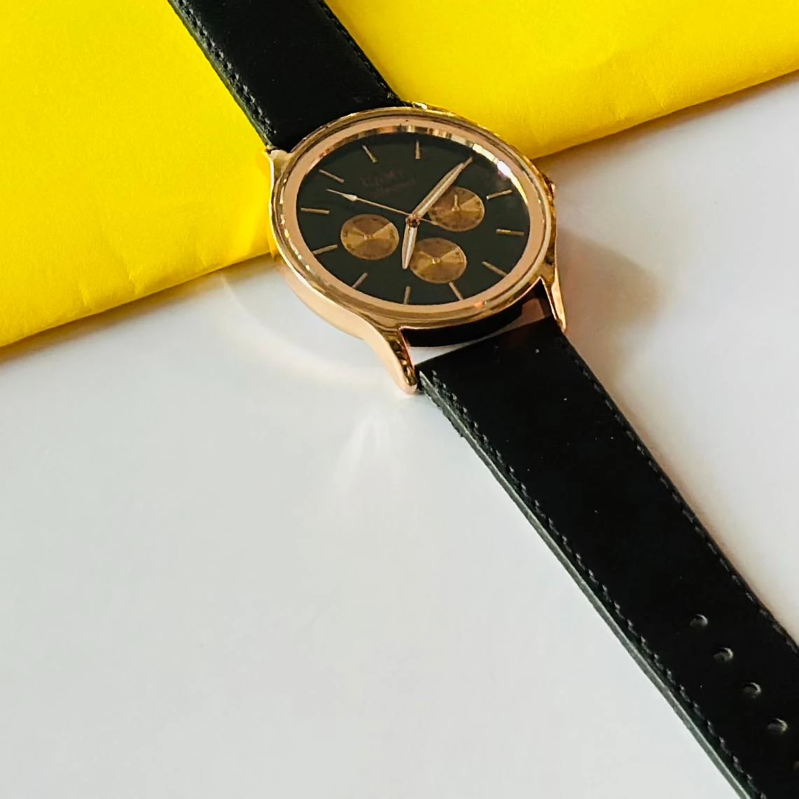 Round analog watch with a black leather strap