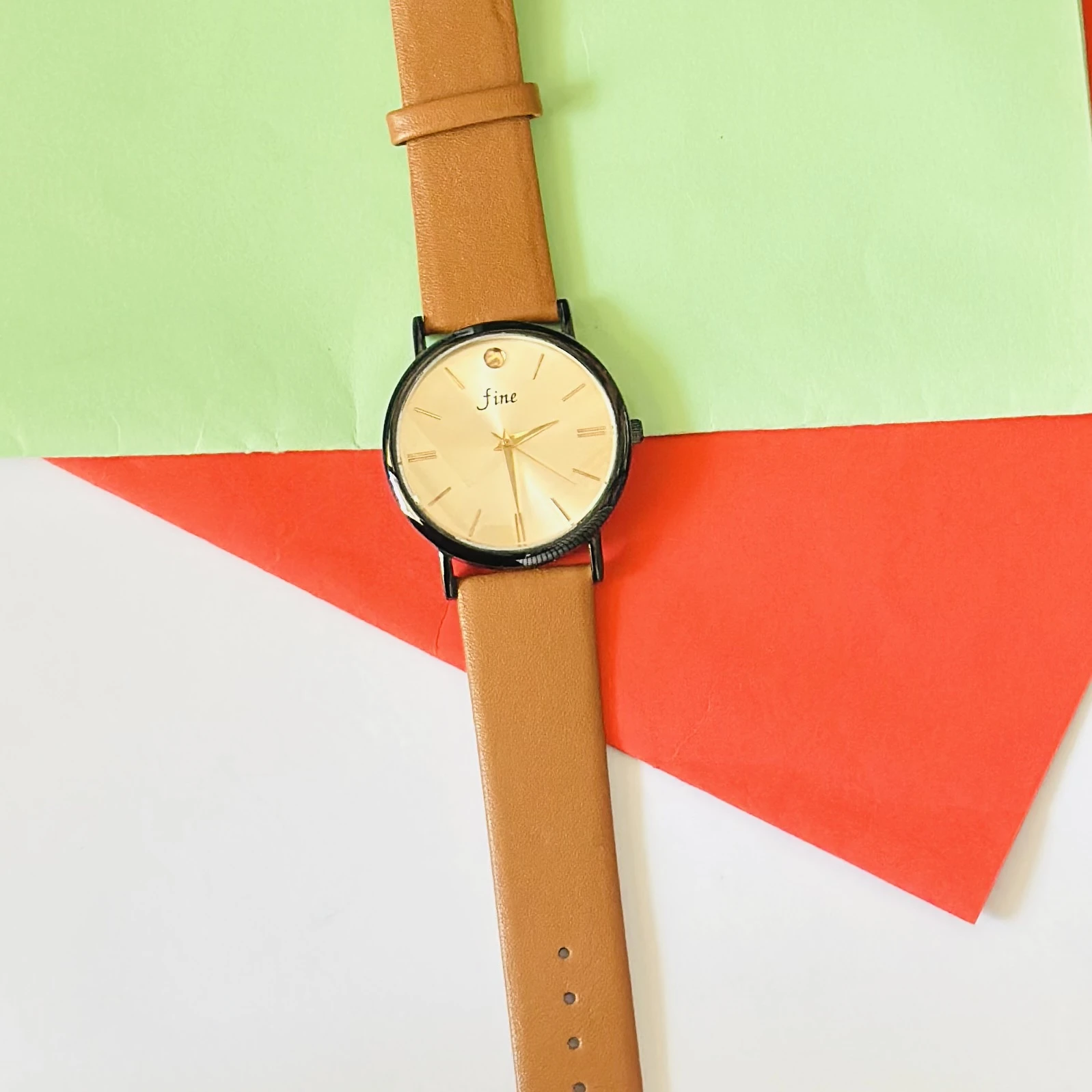 Analog wristwatch with a gold-tone case and a brown leather strap.