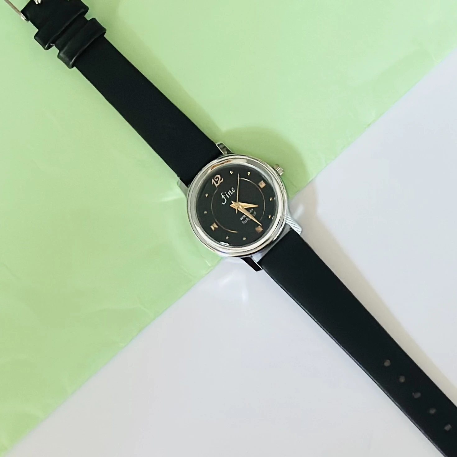 Black analog watch with a black strap.