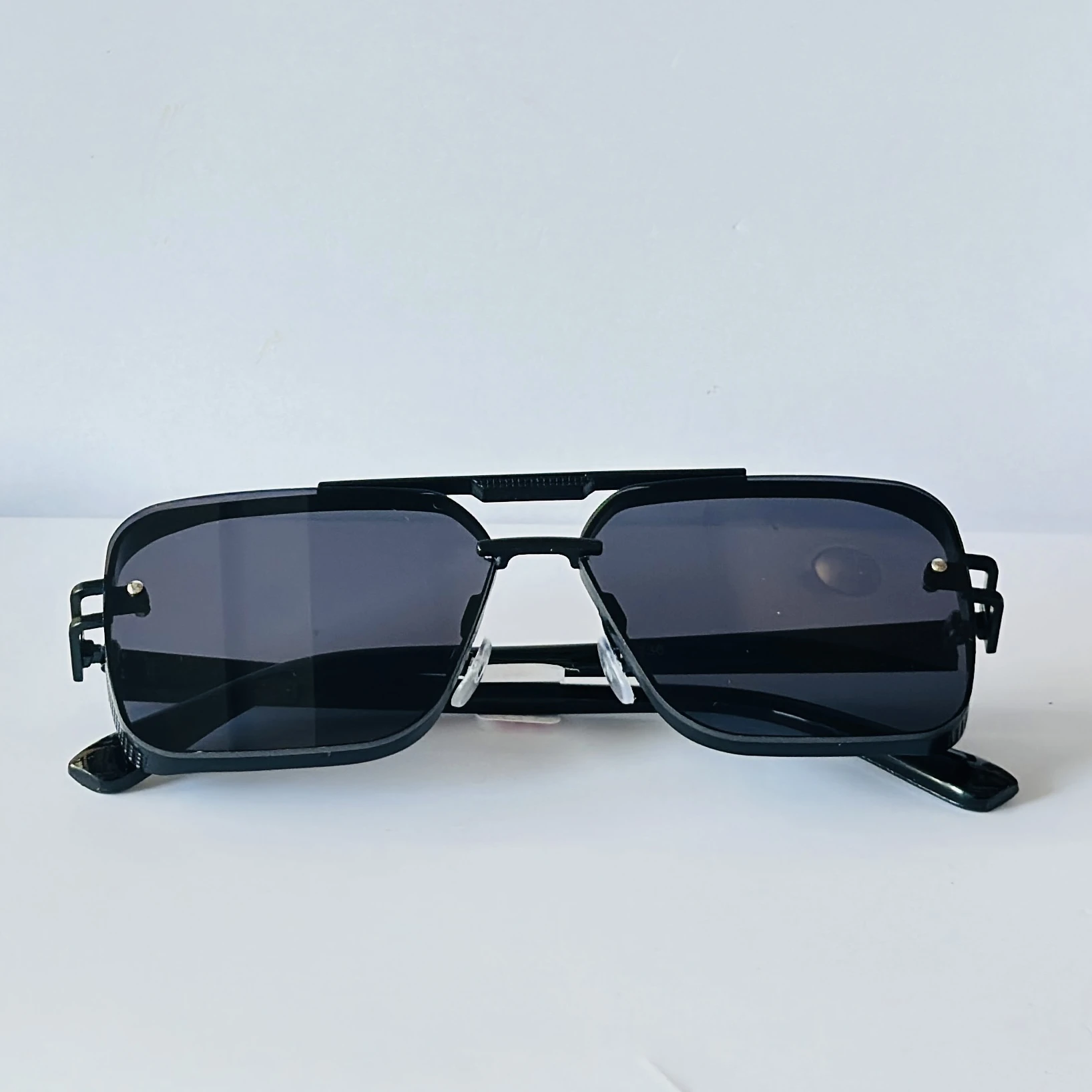 Black sunglasses feature a square frame