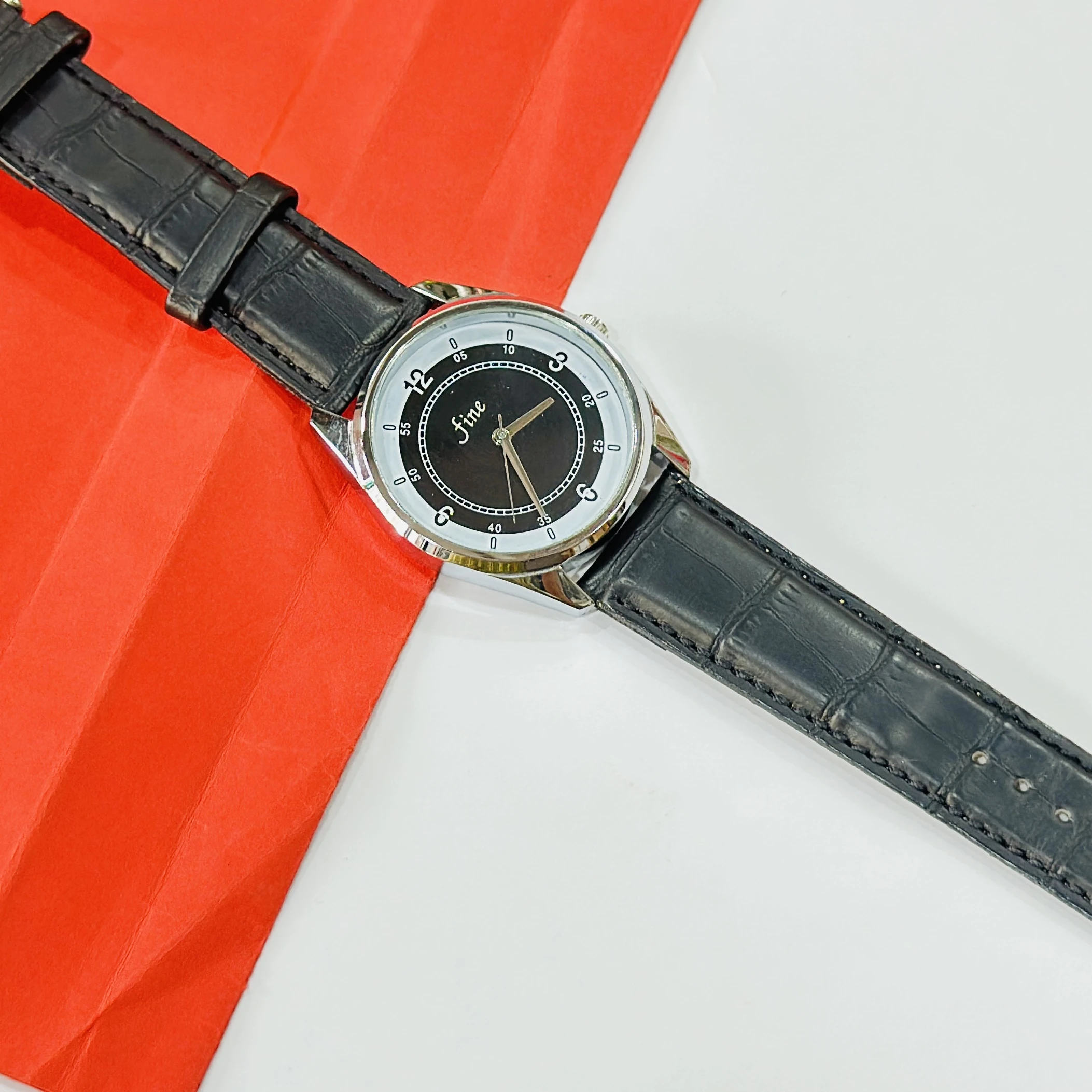 wrist watch with a black leather band and a silver-toned case.