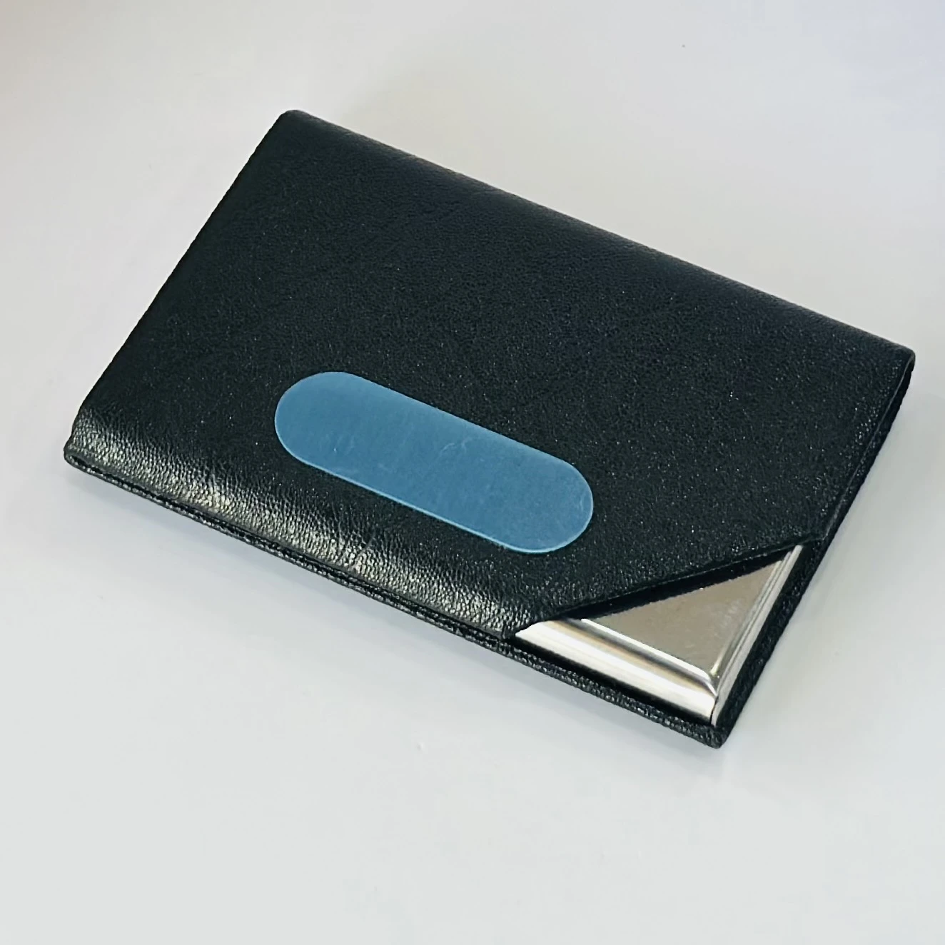 Black faux leather and metal business card holder.