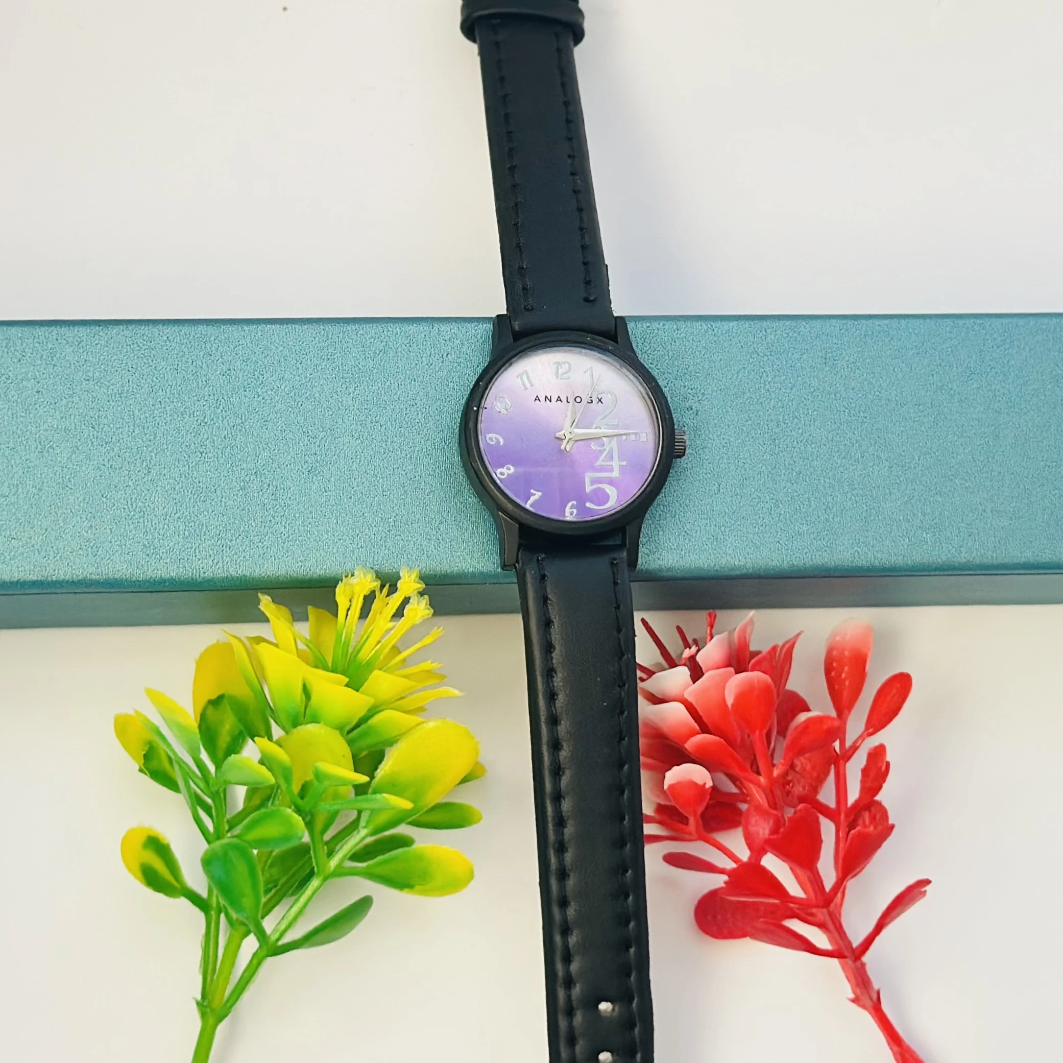 purple analog watch with a black leather strap.