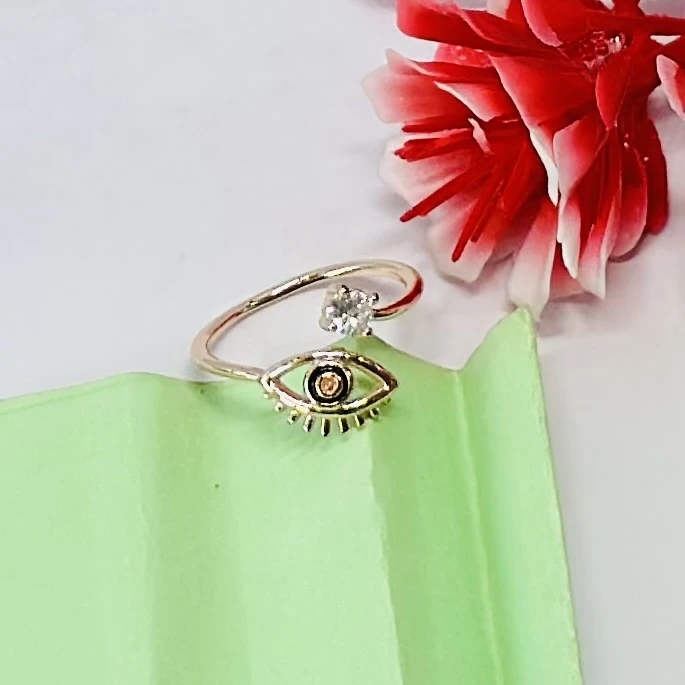 An adjustable gold-toned evil eye ring featuring a cubic zirconia accent.