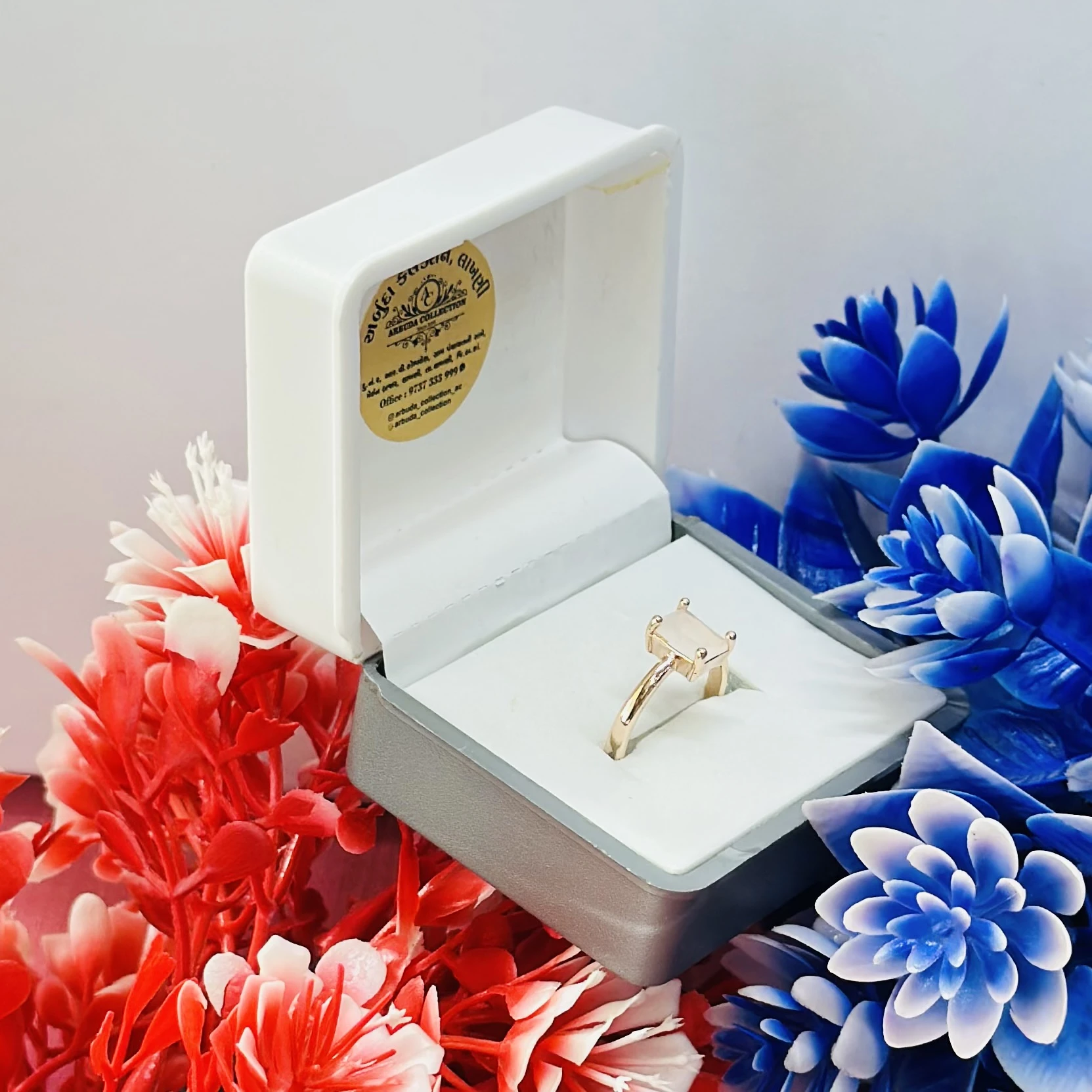 Rose gold-toned ring with a square-cut white stone.