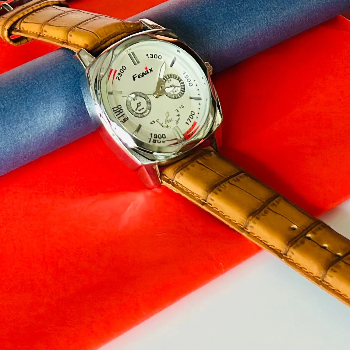 Round analog watch with a brown leather strap
