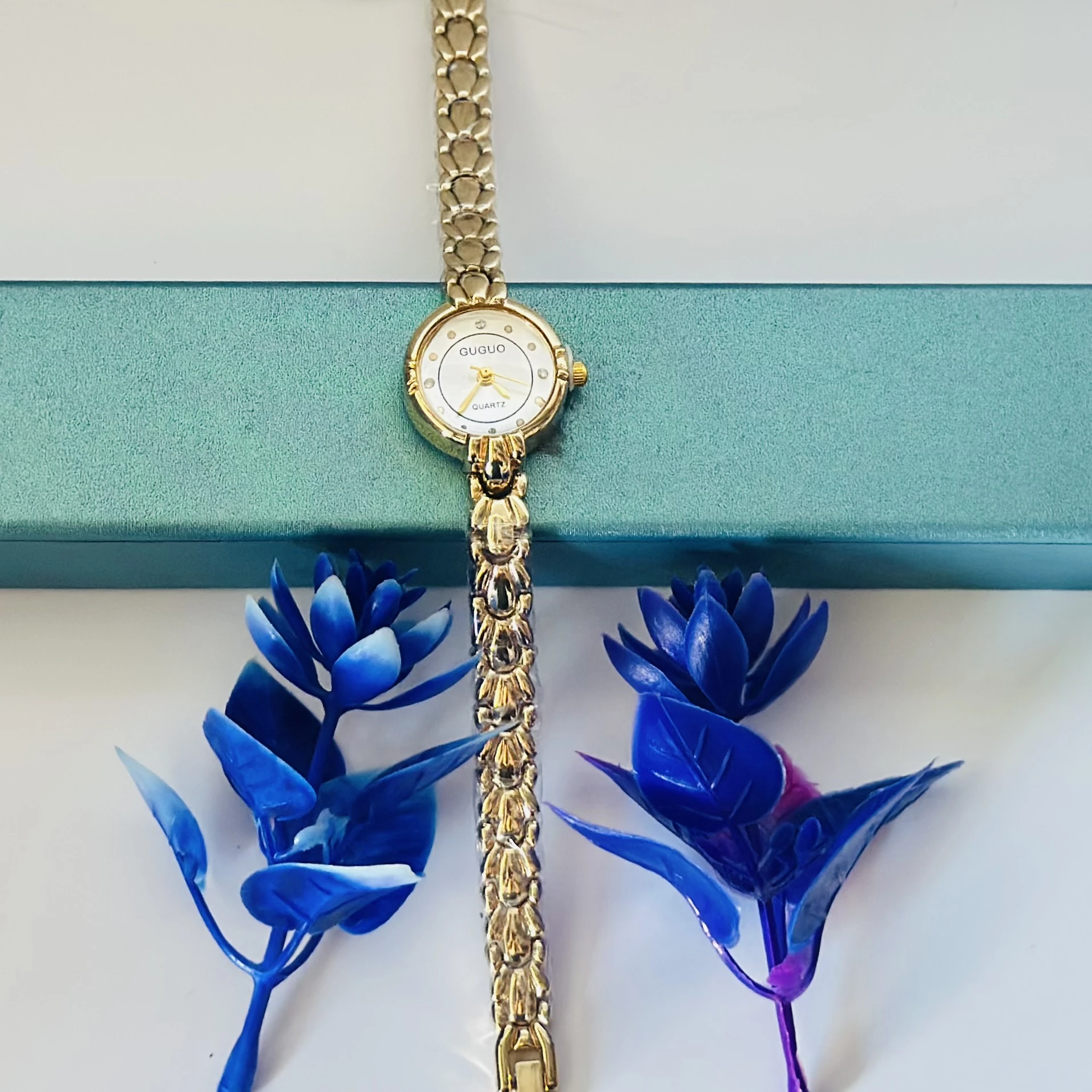 gold-tone GUGUO quartz choker watch with a round white face.