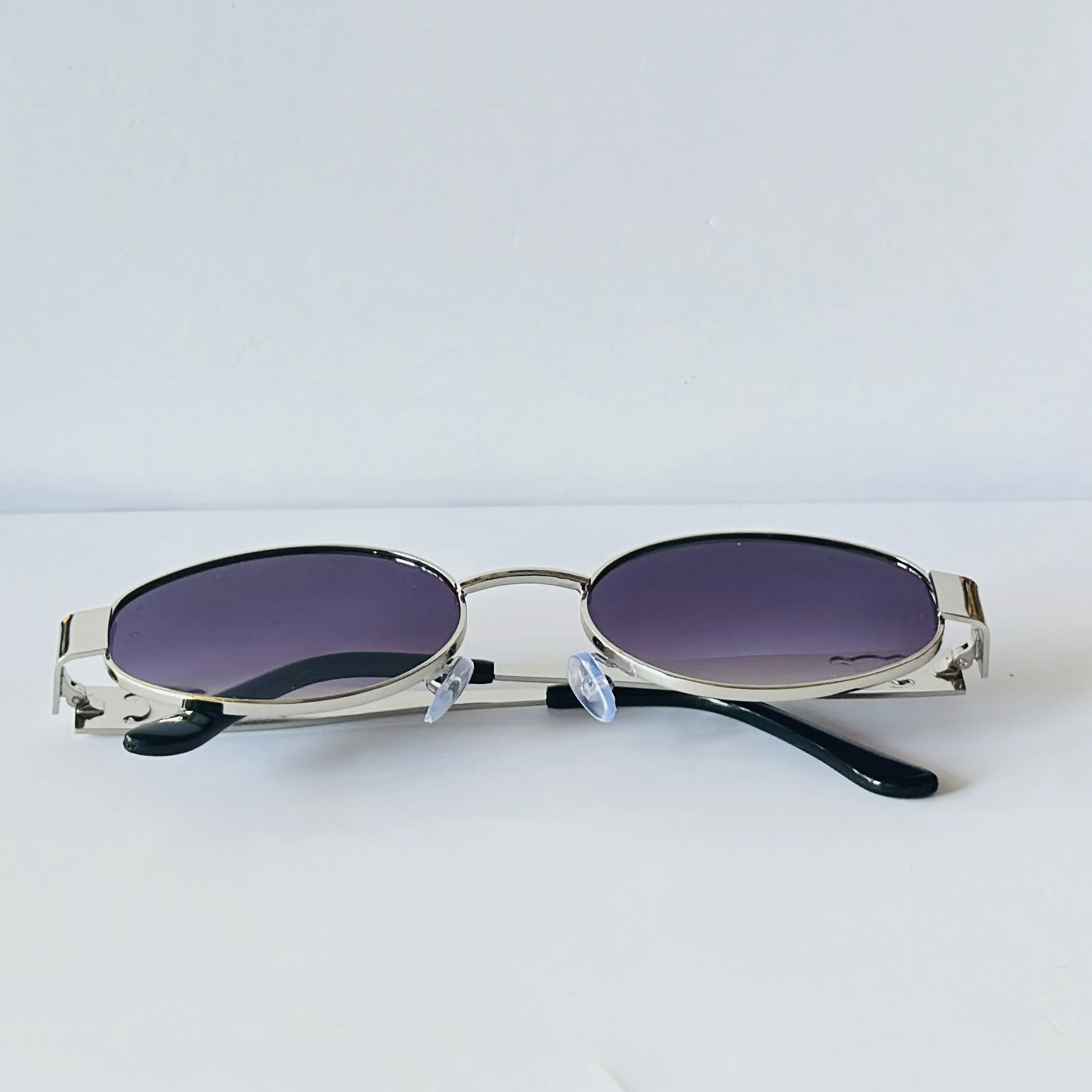 vintage-style metal sunglasses featuring purple oval lenses.
