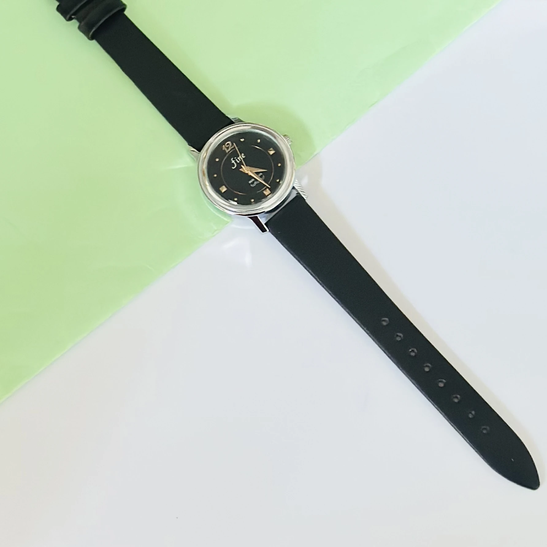 Black analog watch with a black strap.