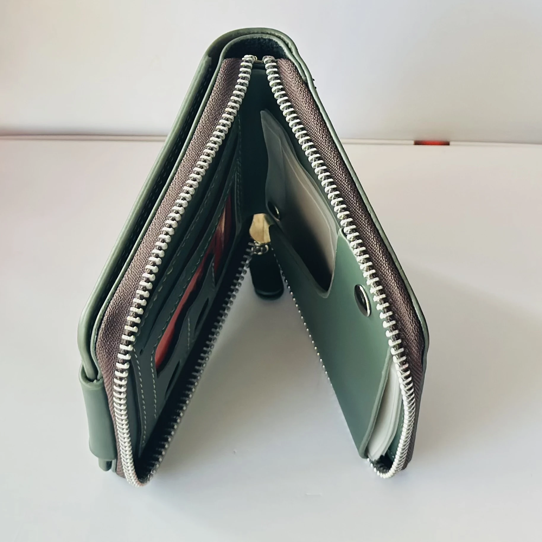 Balisi bifold leather wallet in green with a button closure.