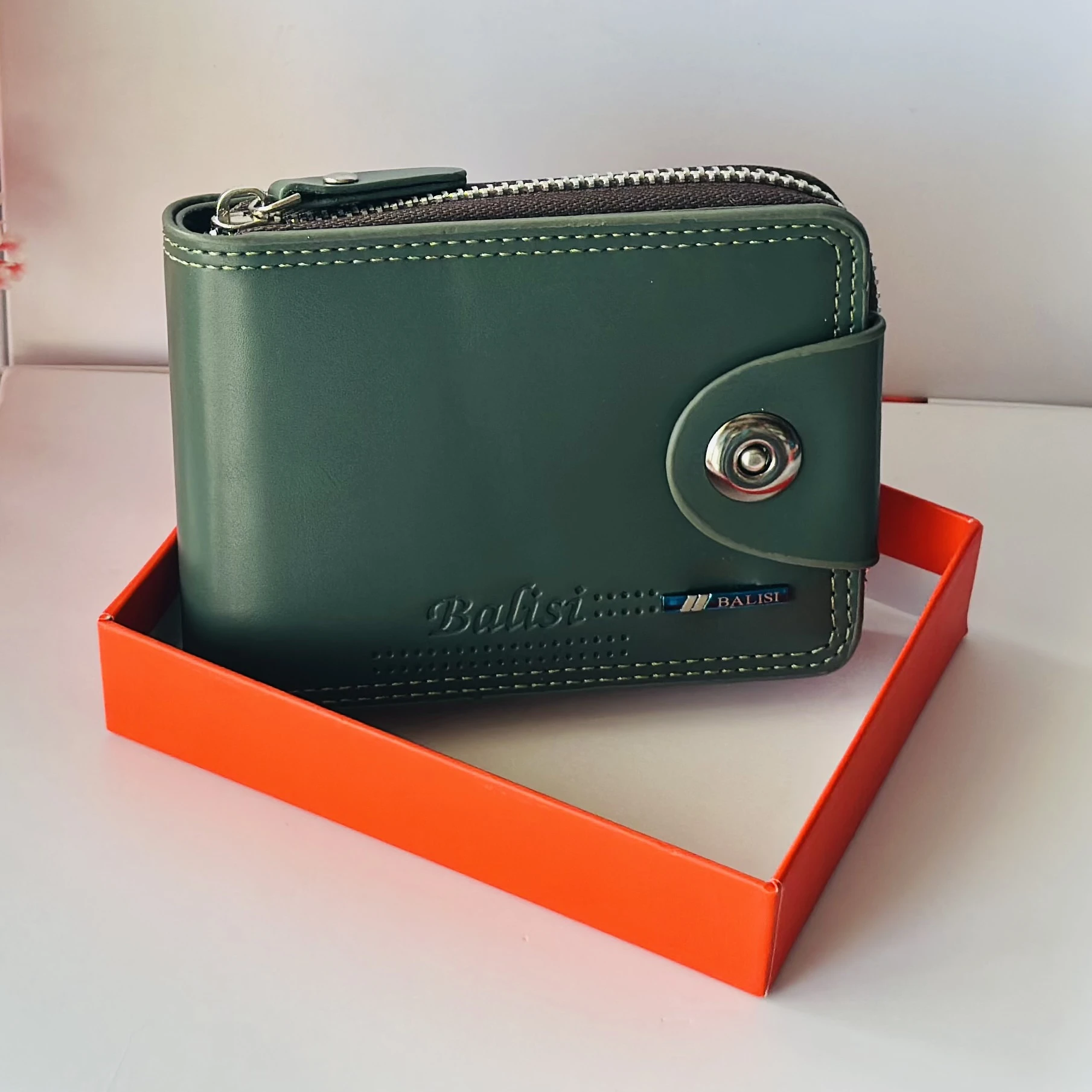 Balisi bifold leather wallet in green with a button closure.
