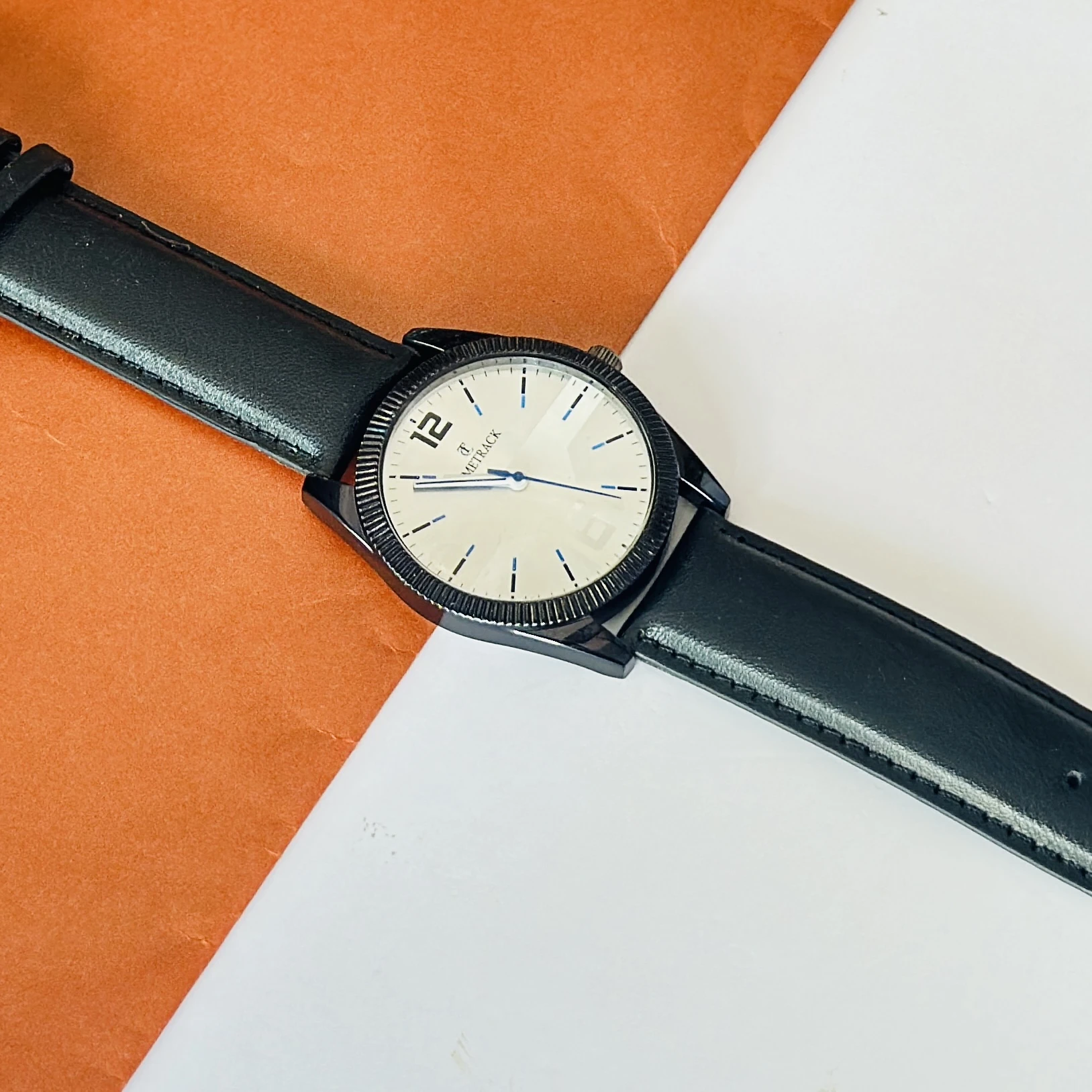 Timrack analog wristwatch featuring a silver-toned bezel, a black dial