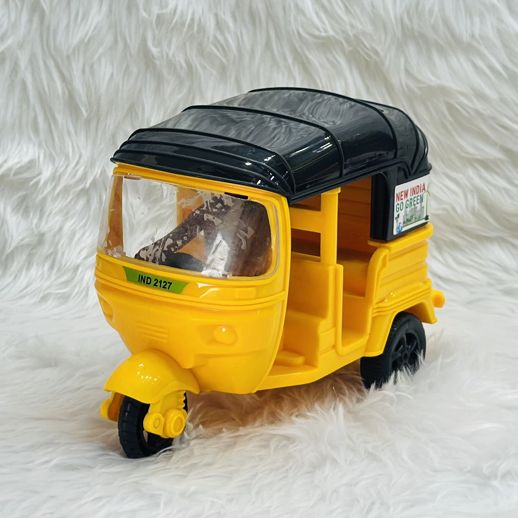 Yellow plastic toy auto rickshaw.