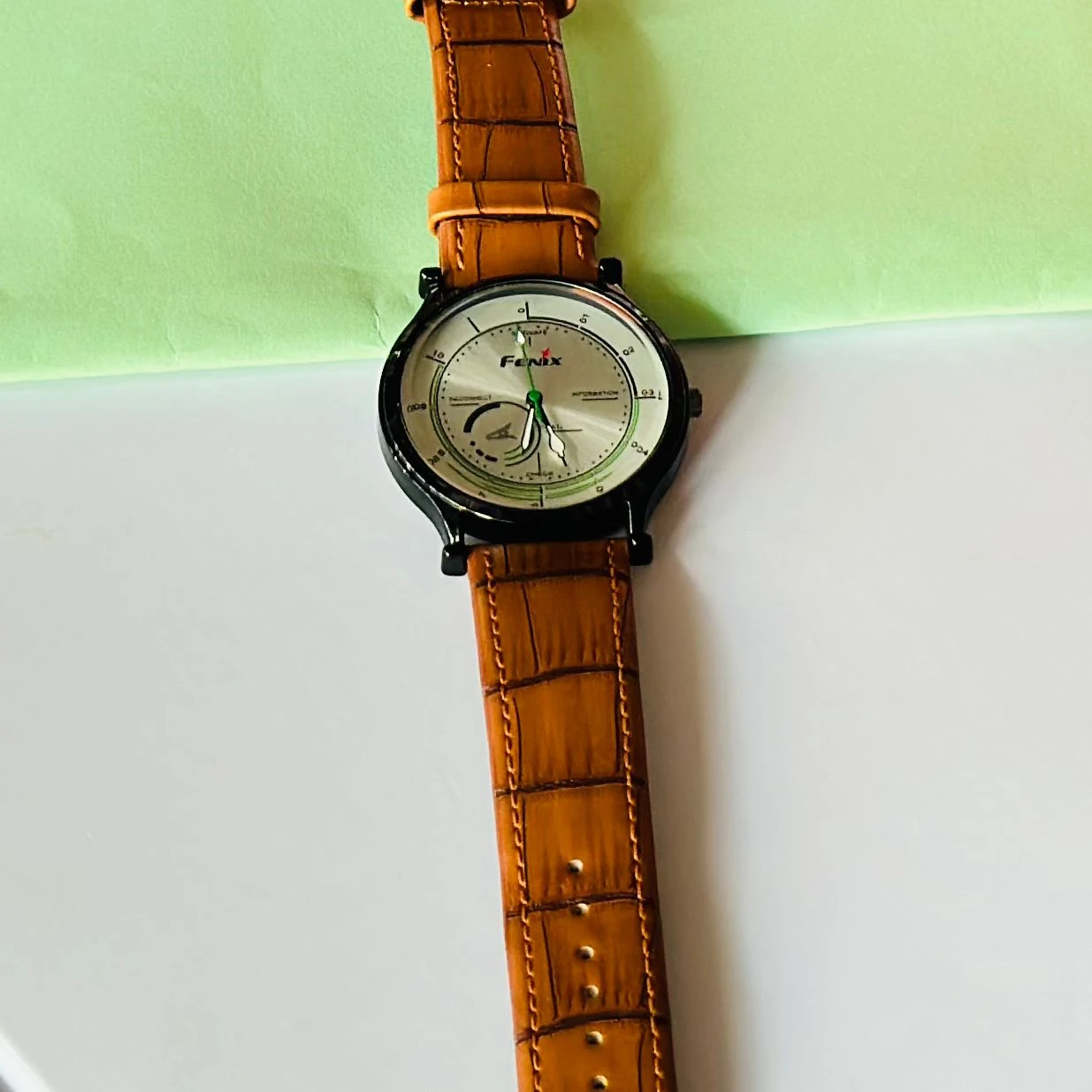 Round  analog watch with a brown leather strap