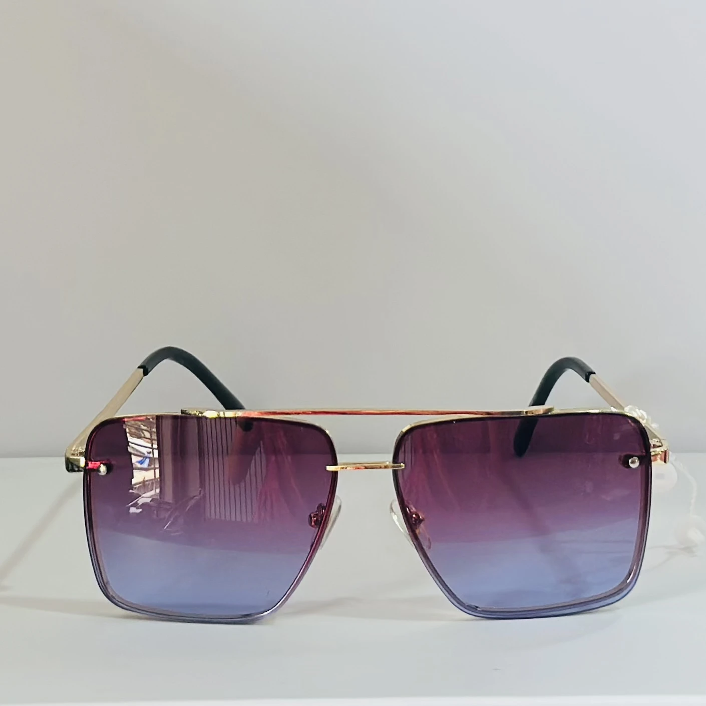 Sunglasses in a gold-tone metal frame with gradient lenses.