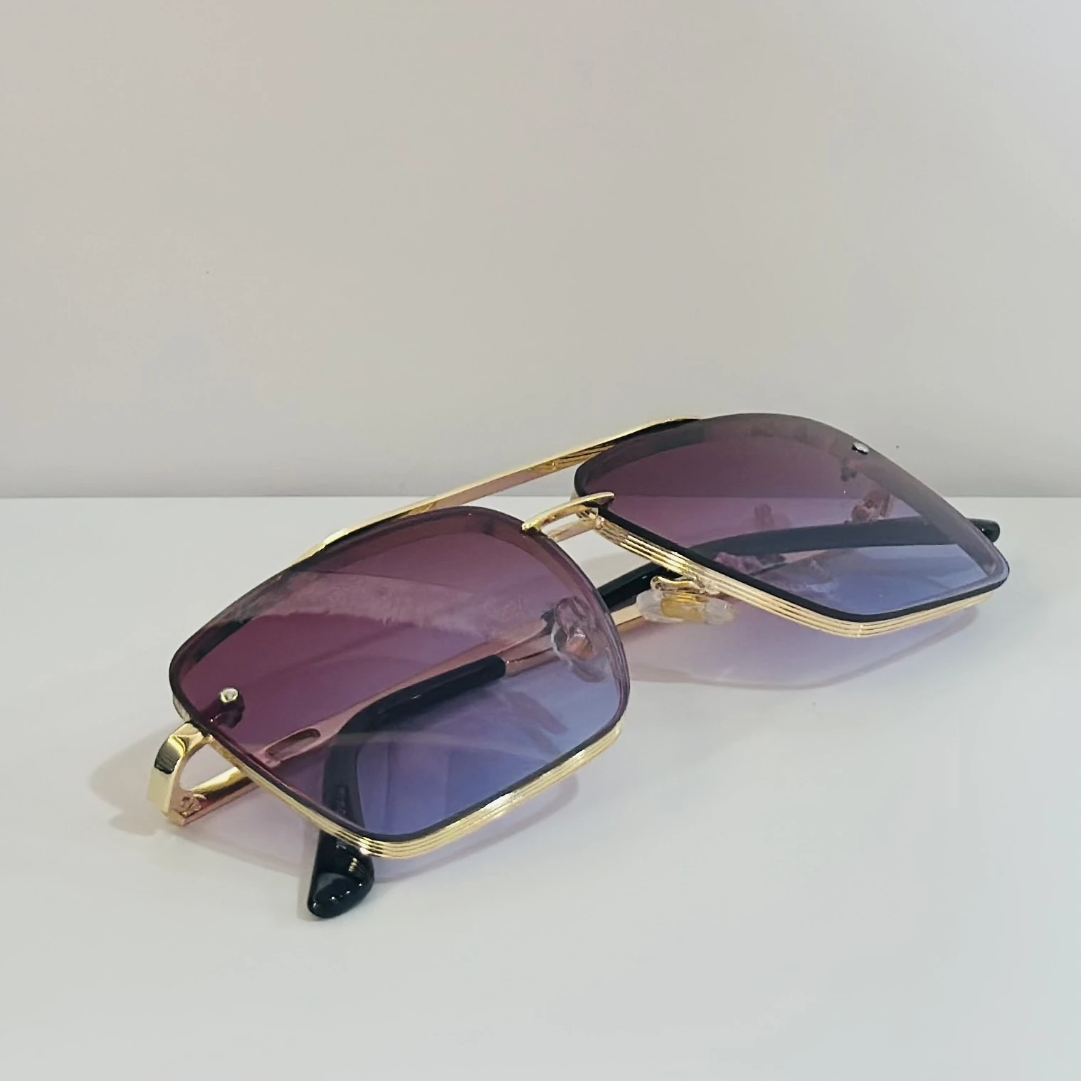 Sunglasses in a gold-tone metal frame with gradient lenses.