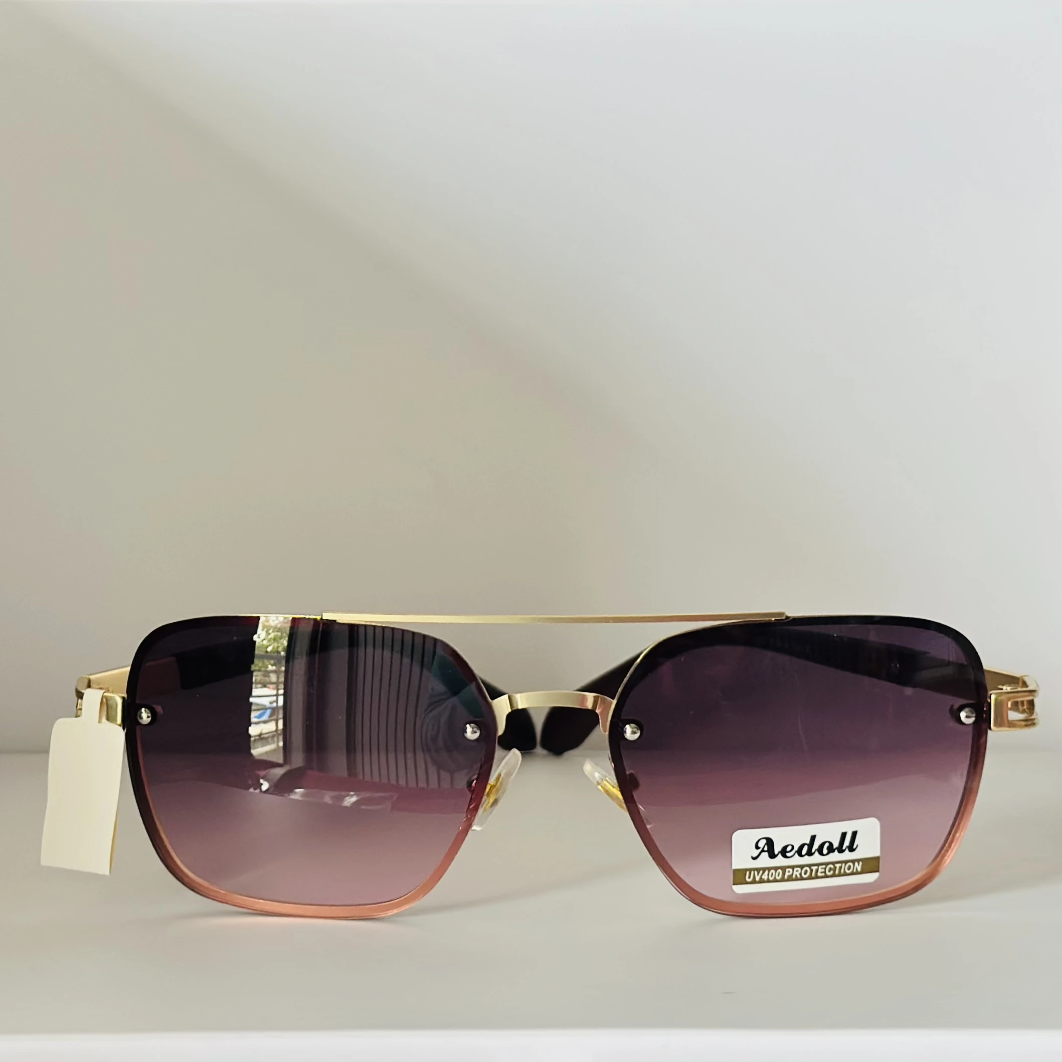 pair of Aedoll Goggle sunglasses with a gold metal frame and pink gradient lenses.