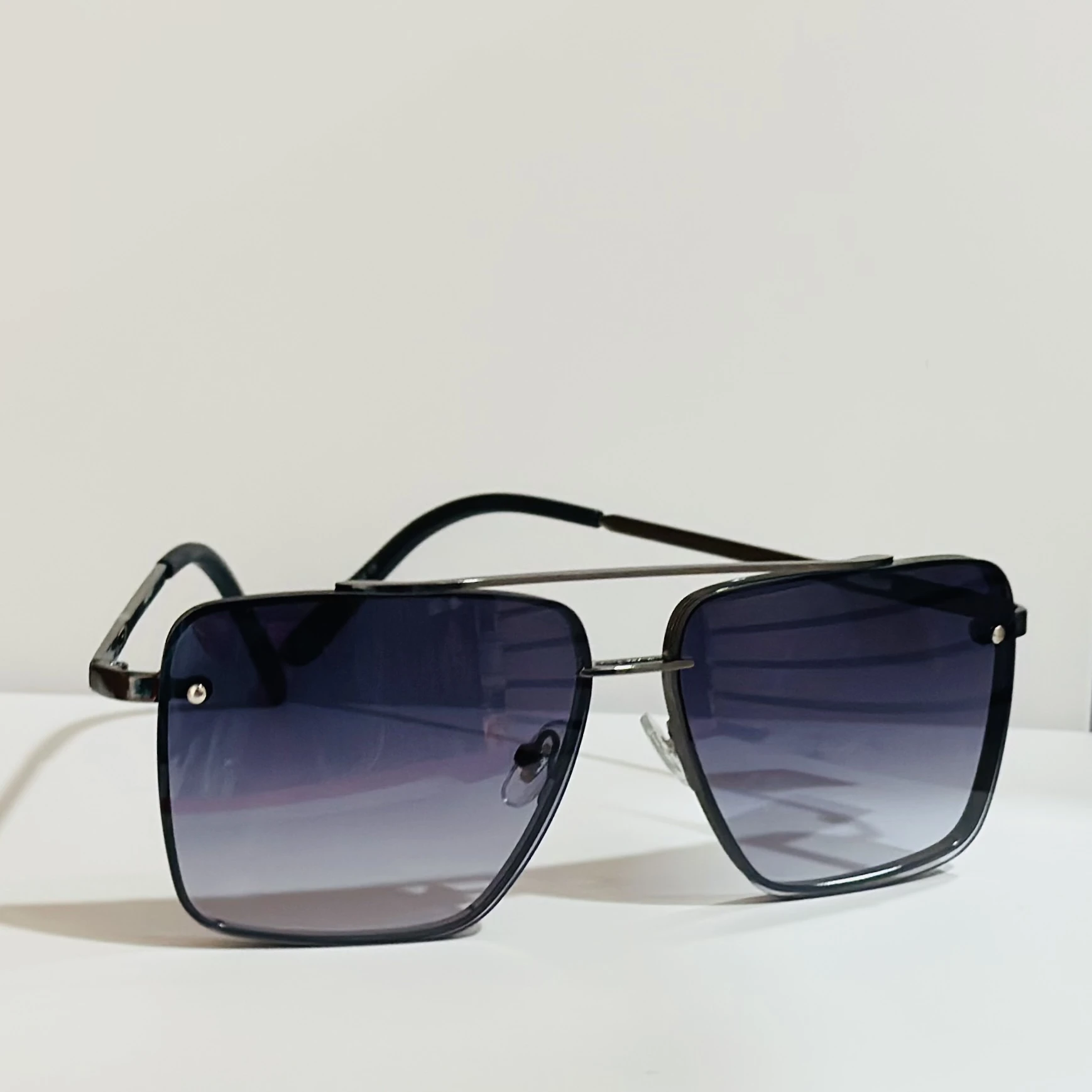 pair of square aviator sunglasses with a black metal frame and gradient lenses.