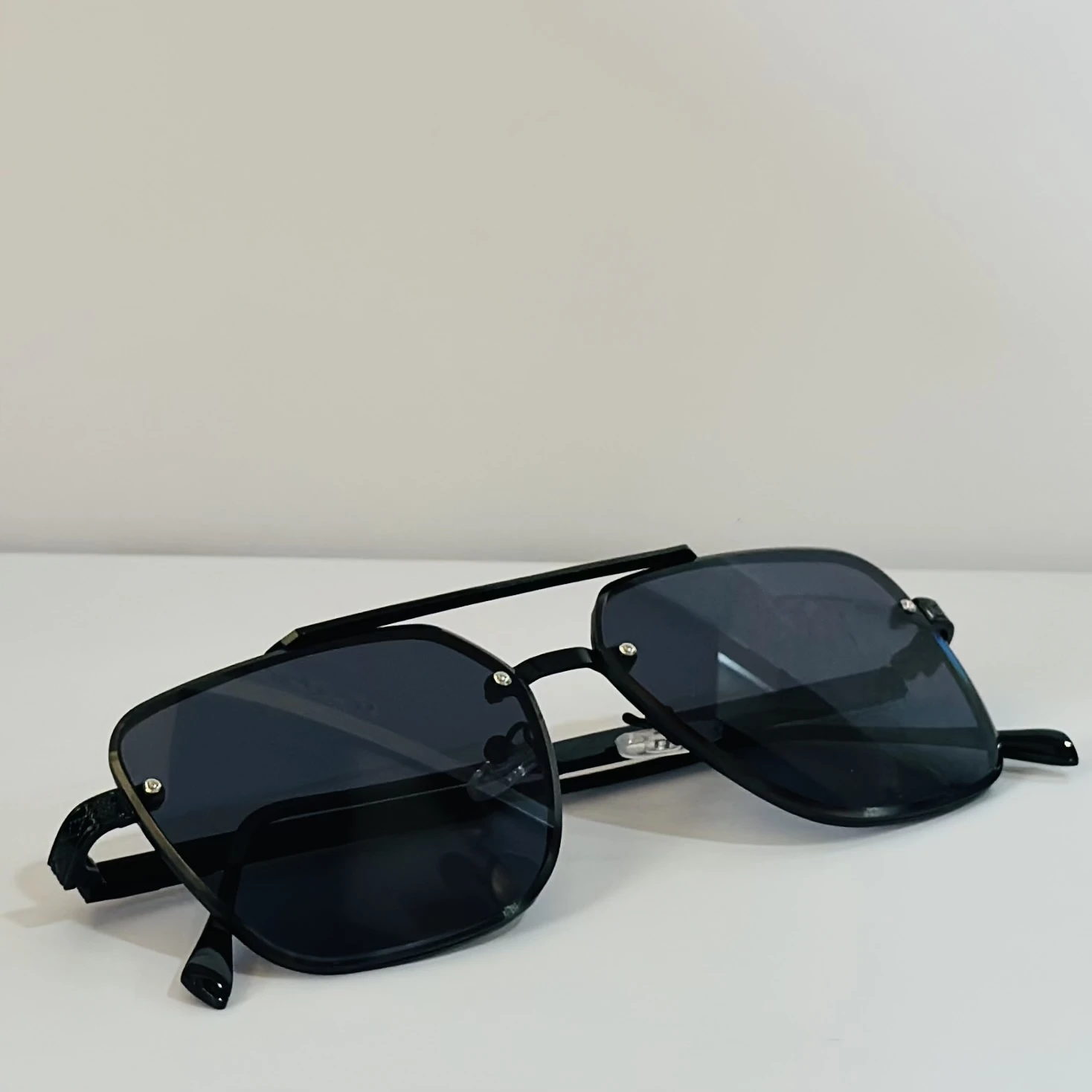 pair of MOONX Celebrity black UV protected sunglasses with a black frame.