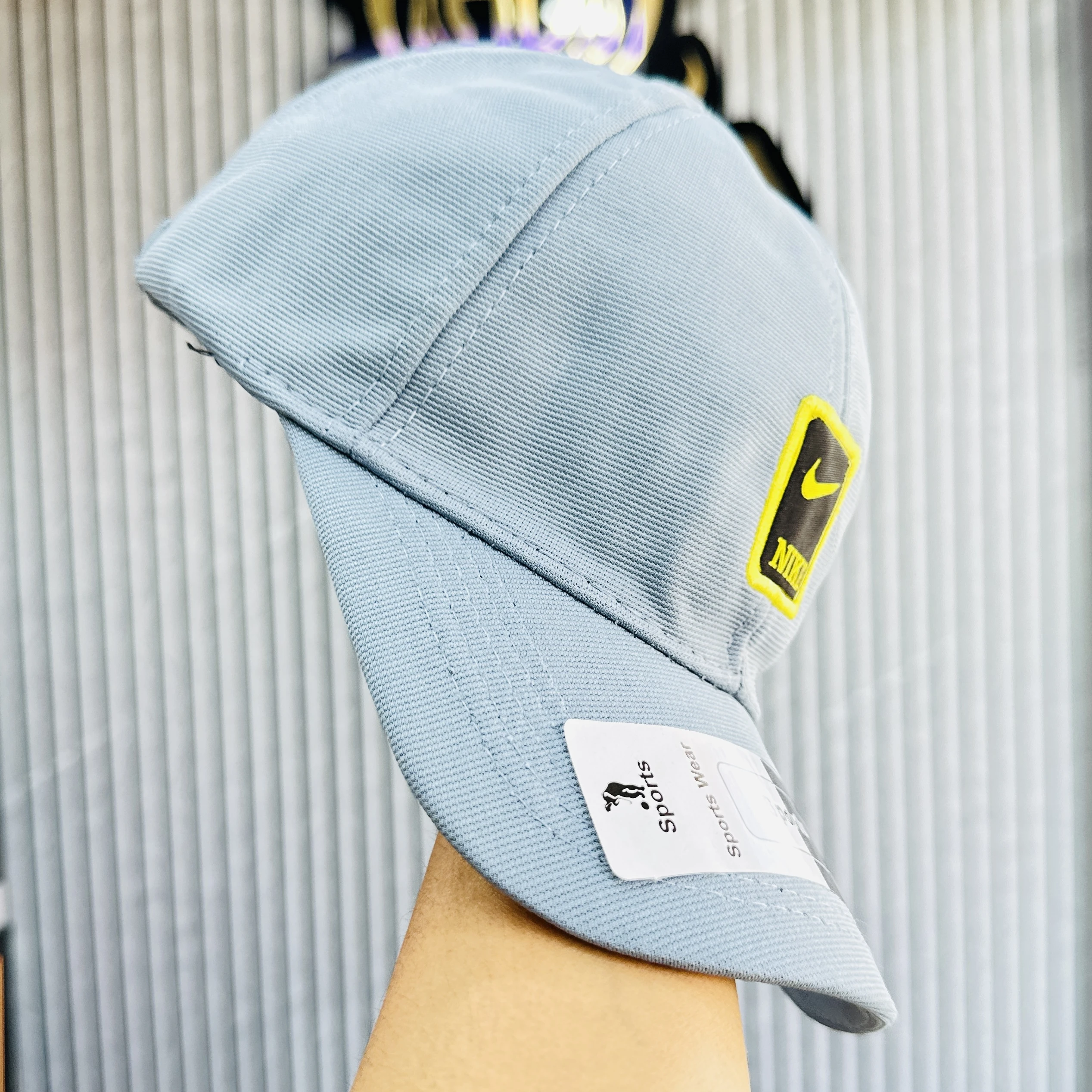 Blue Nike baseball cap featuring a yellow and black logo patch on the front.