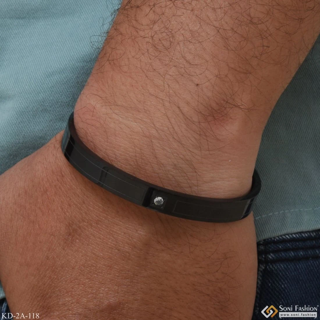 Black stainless steel kada bracelet with a single crystal accent.