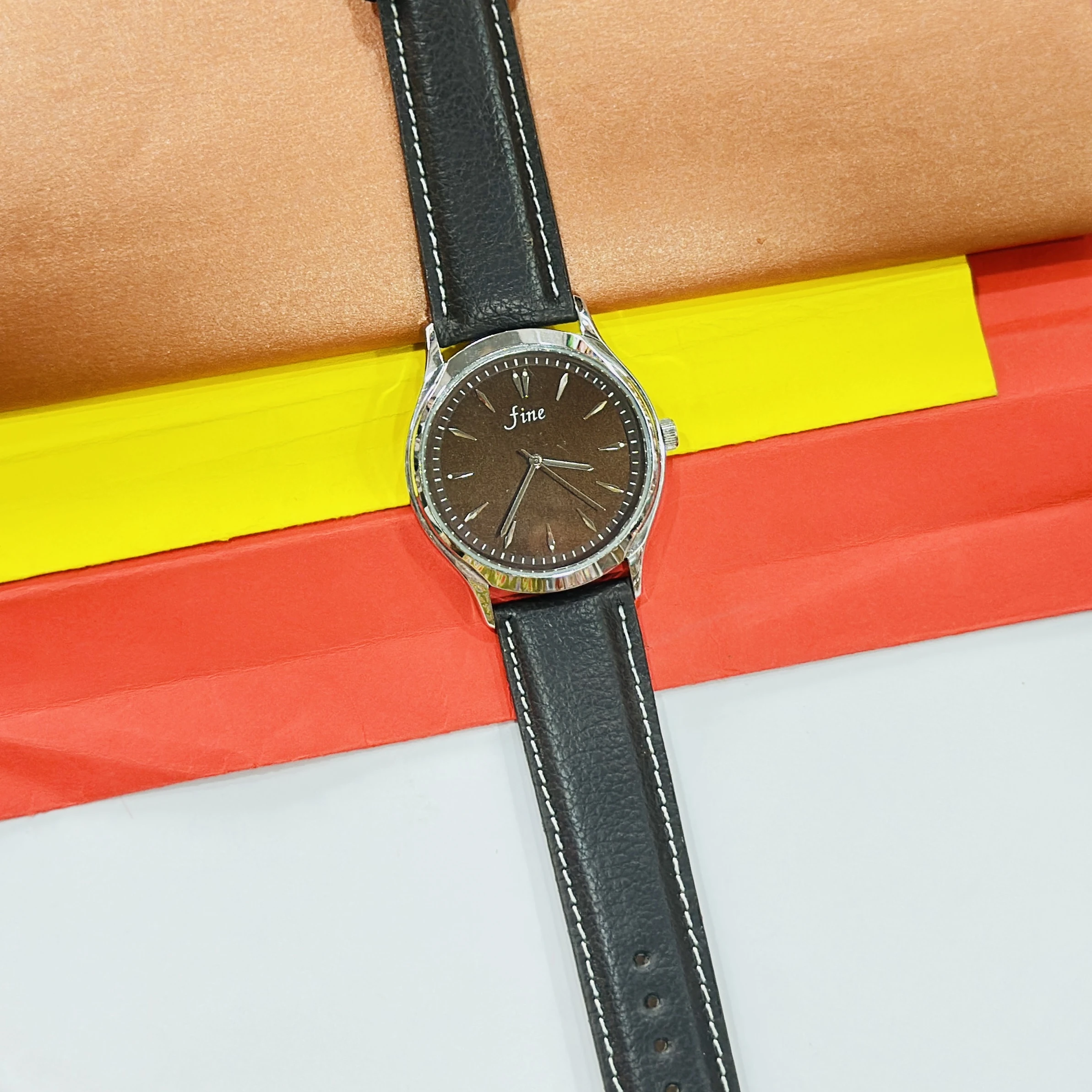 Fine" brand wristwatch featuring a black strap