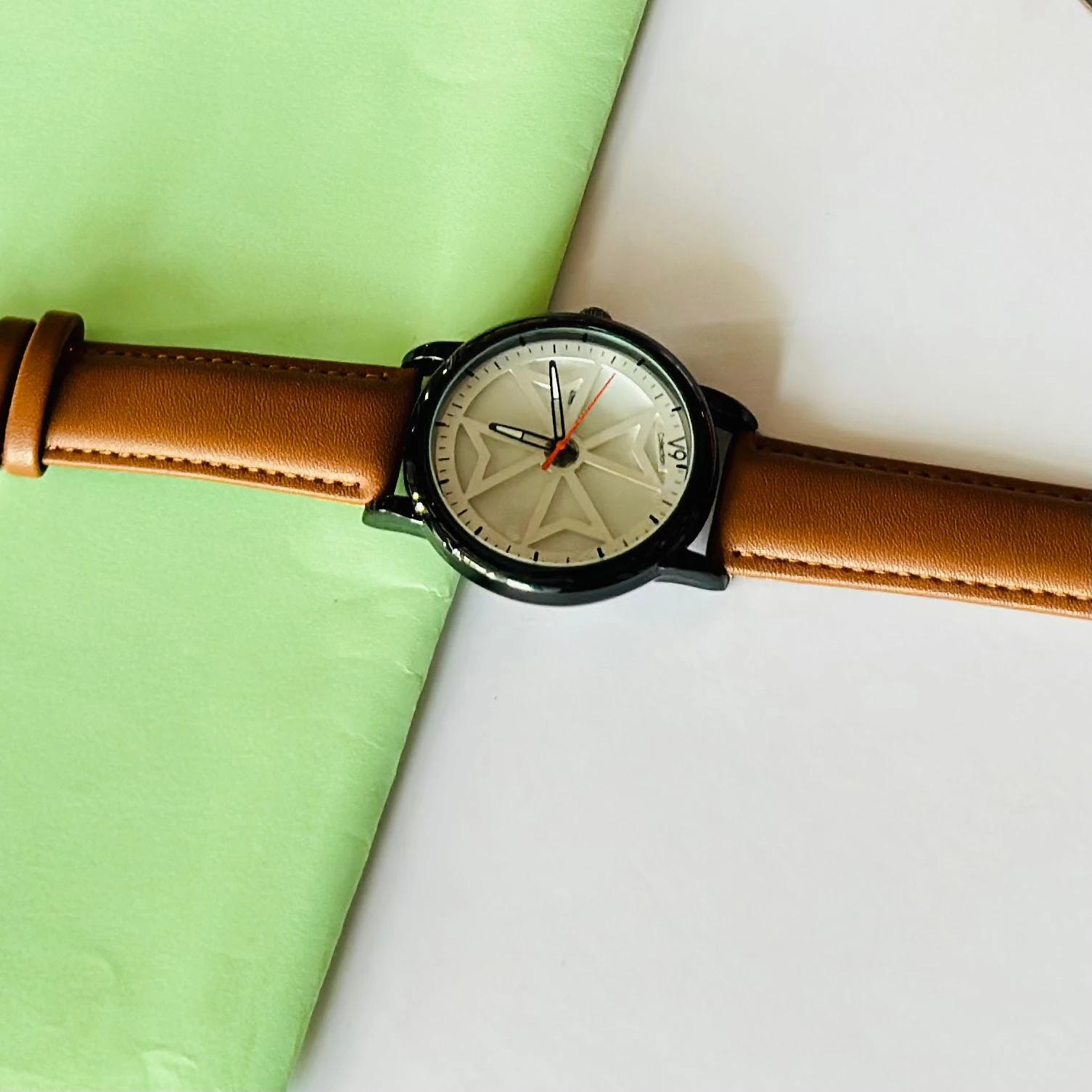 Round analog watch with a brown leather strap