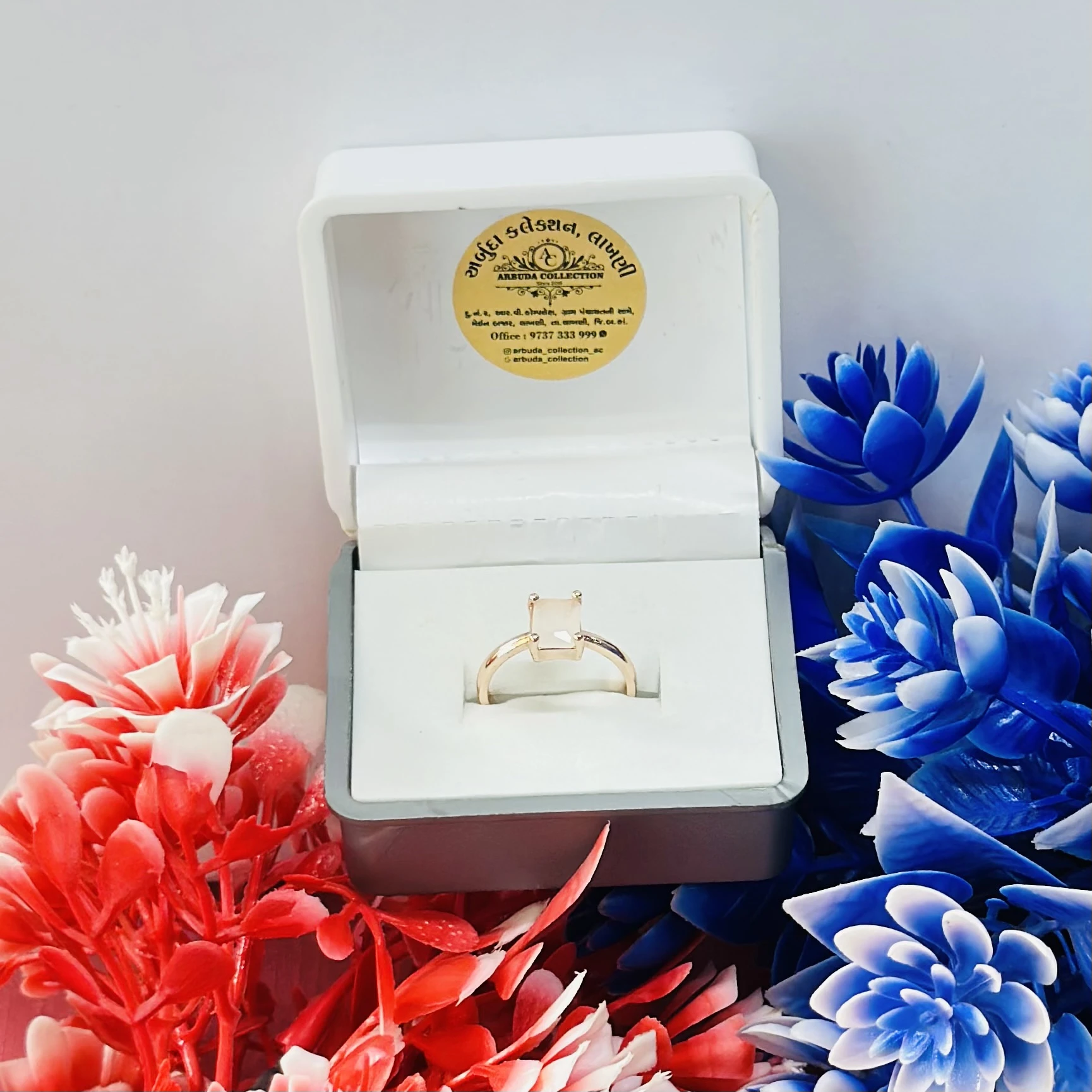 Rose gold-toned ring with a square-cut white stone.