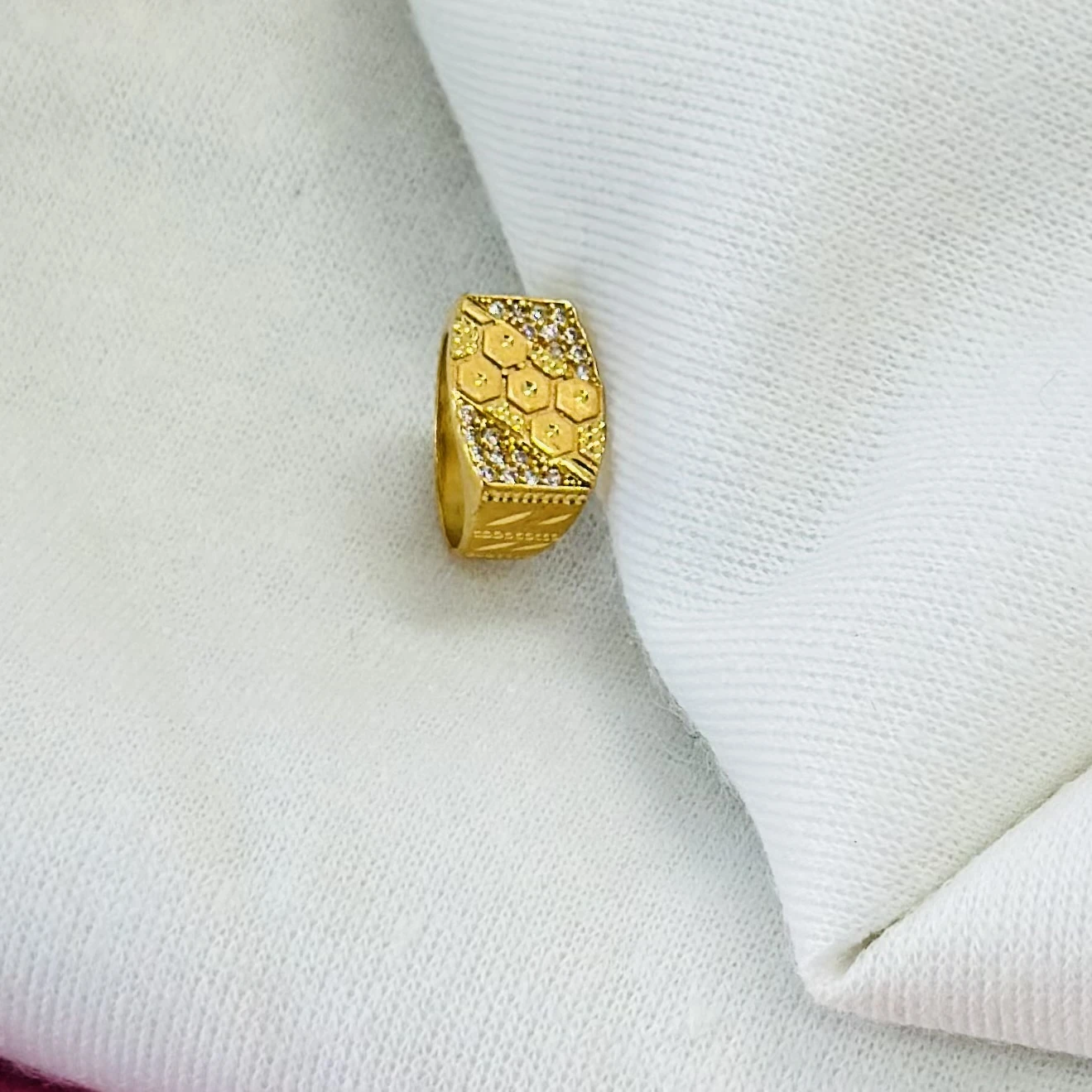 Gold men's ring with a hexagonal design and small white stones.