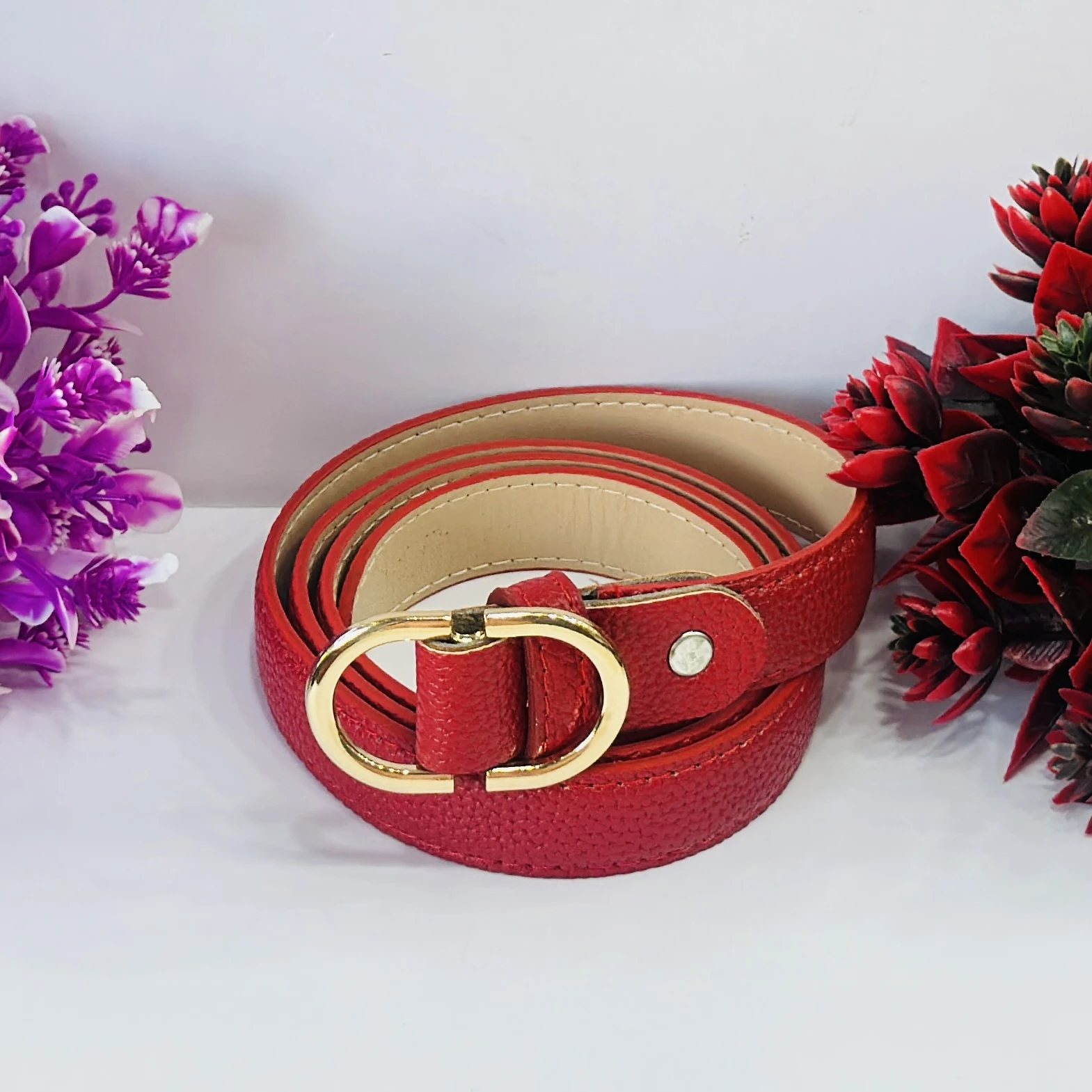 Red  leather belt with a gold-colored buckle.