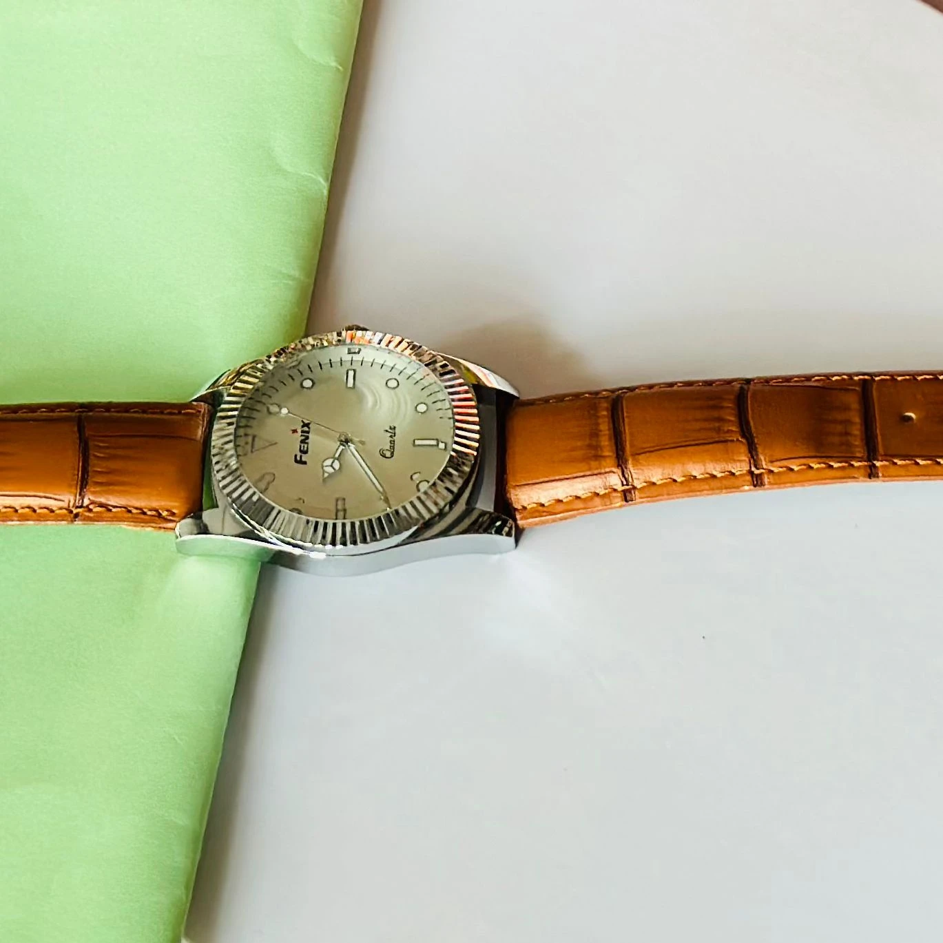 Round analog watch with a brown leather strap