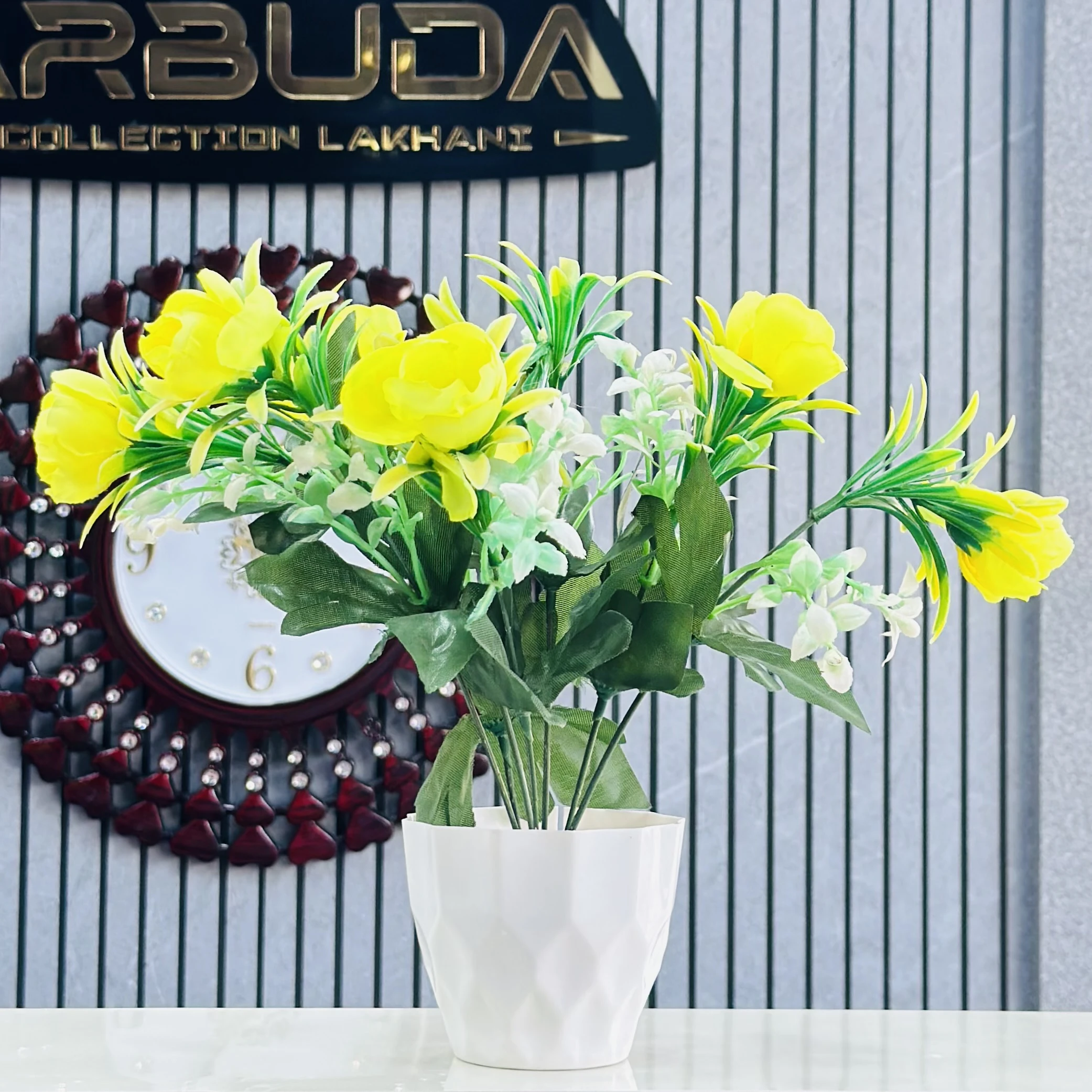 Yellow flower arrangement in a white ceramic pot.