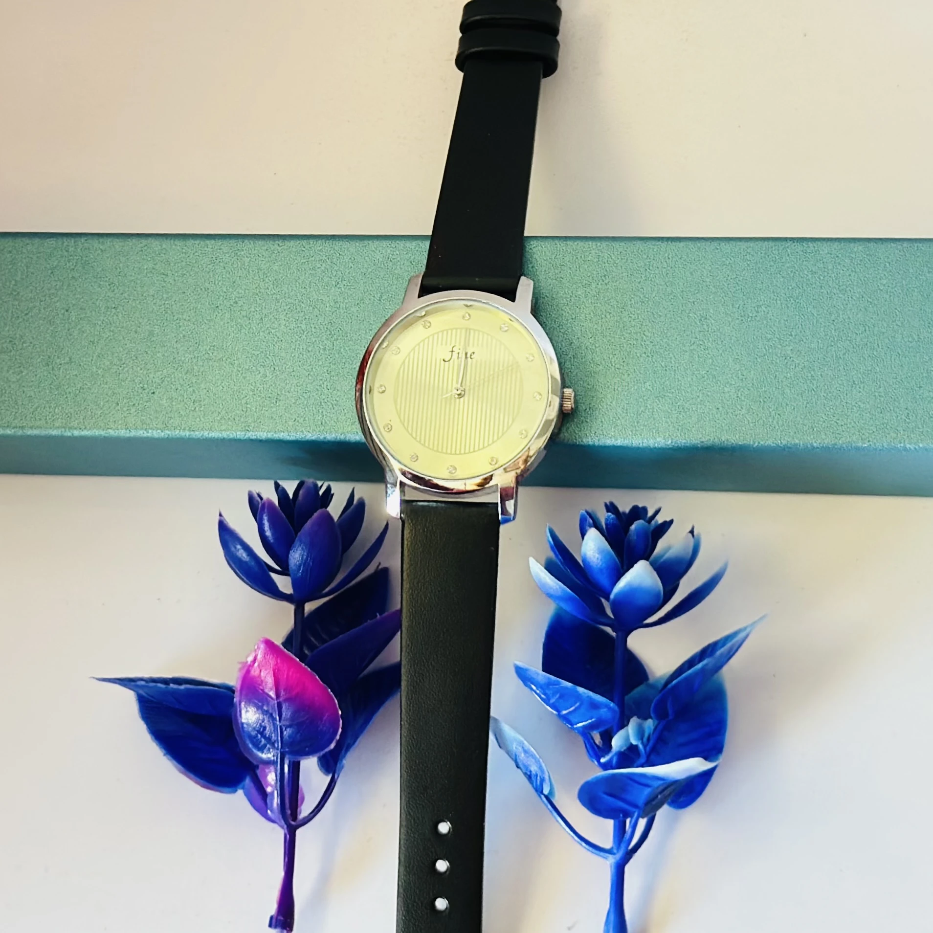 women's round leather watch in silver and black with a white dial