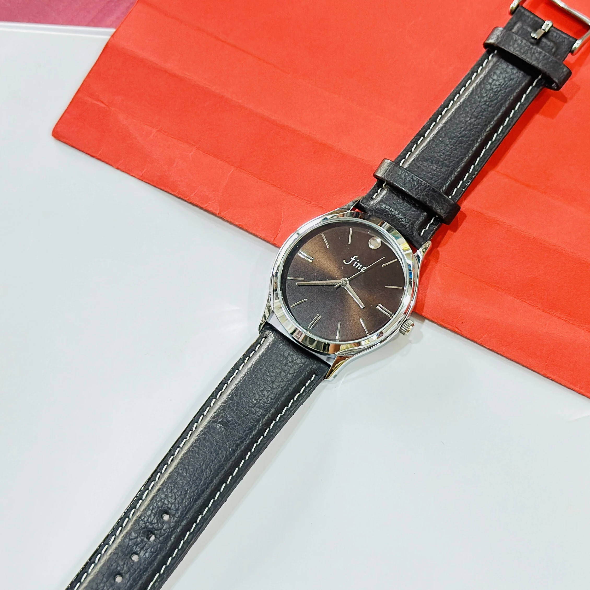 wristwatch featuring a black textured leather strap