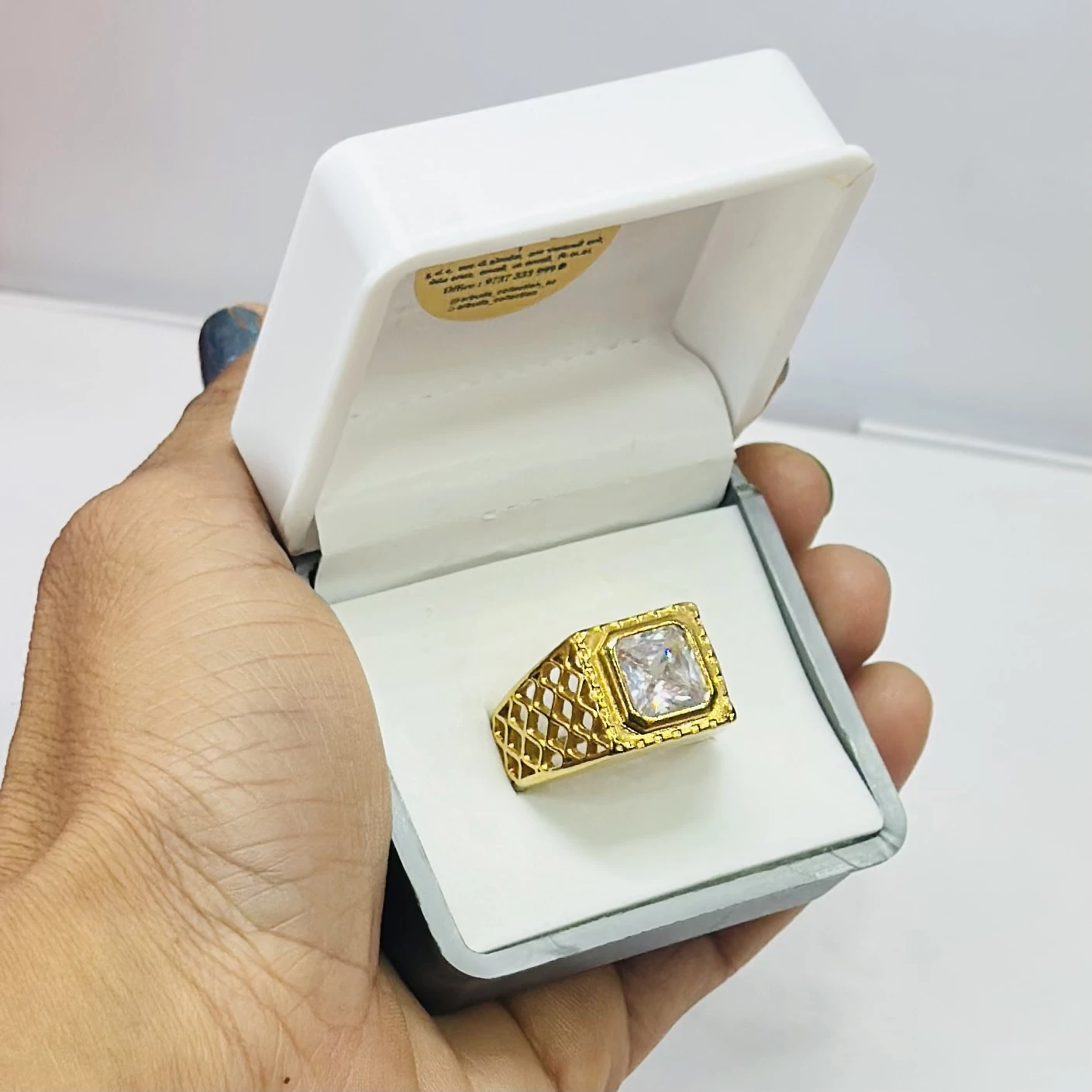 Gold plated men's ring with a square-cut cubic zirconia stone.