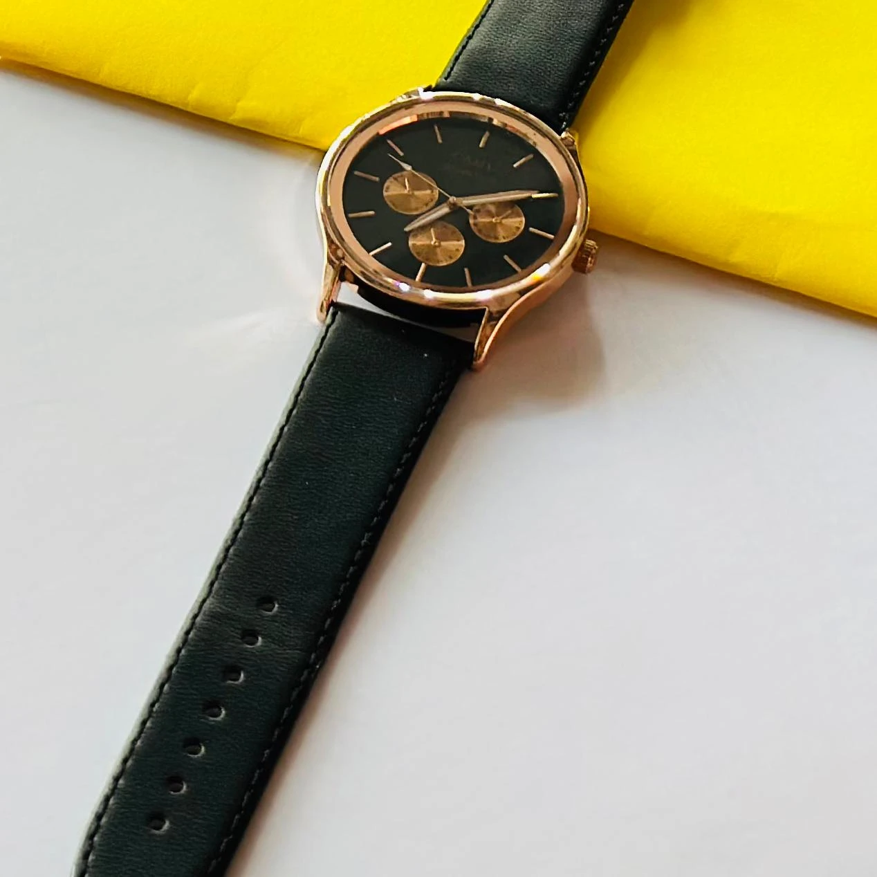 Round analog watch with a black leather strap